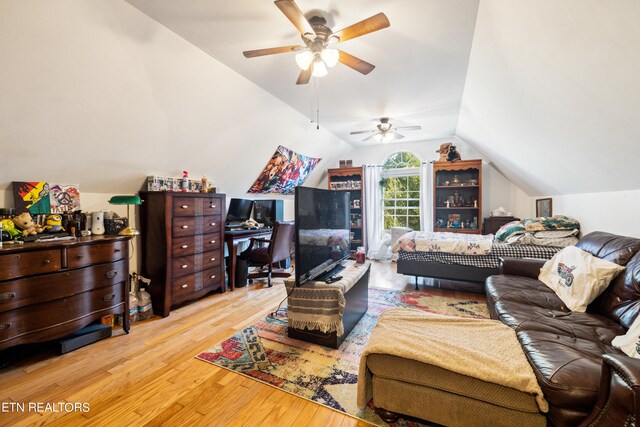 living room with ceiling fan, vaulted ceiling, and light hardwood / wood-style floors