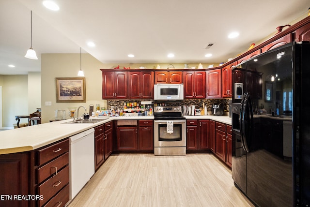 kitchen featuring backsplash, white appliances, decorative light fixtures, and sink