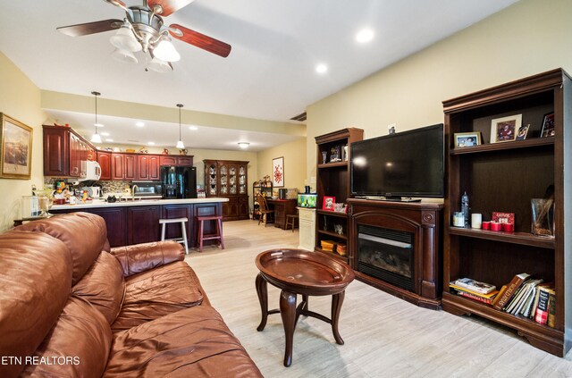 living room with ceiling fan and light hardwood / wood-style flooring