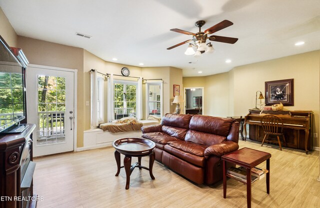 living room featuring light hardwood / wood-style floors and ceiling fan