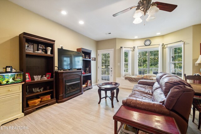 living room with light hardwood / wood-style flooring and ceiling fan