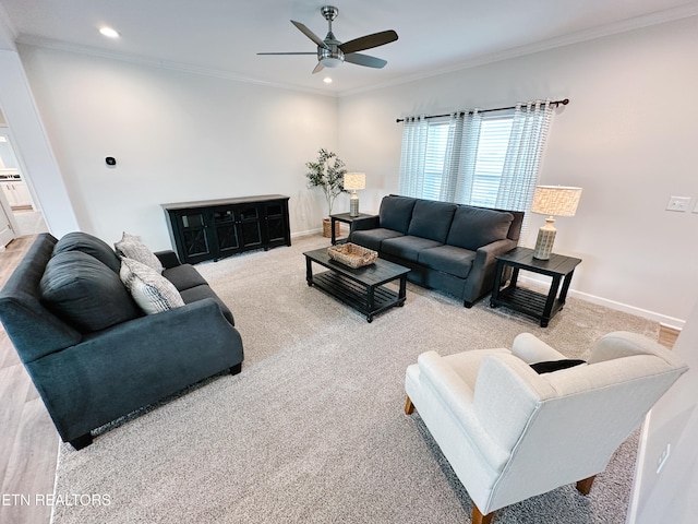 carpeted living room with crown molding and ceiling fan