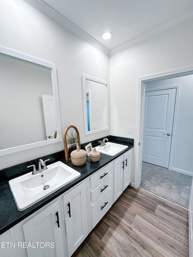 bathroom with crown molding, wood-type flooring, and vanity