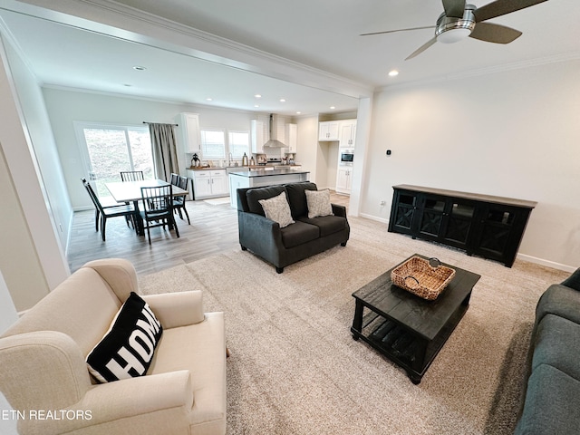 living room with crown molding, ceiling fan, and light wood-type flooring