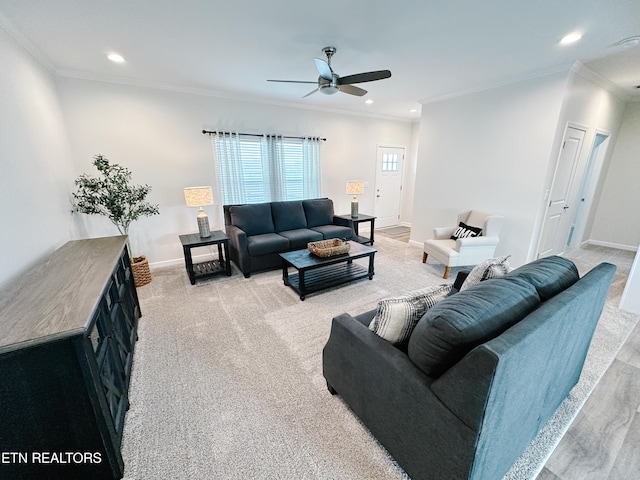 living room with ornamental molding, light carpet, and ceiling fan