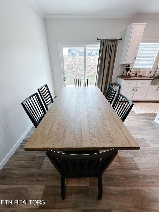 dining area featuring hardwood / wood-style floors and crown molding