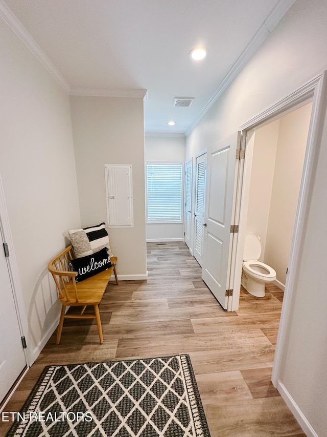 hallway featuring crown molding and light wood-type flooring