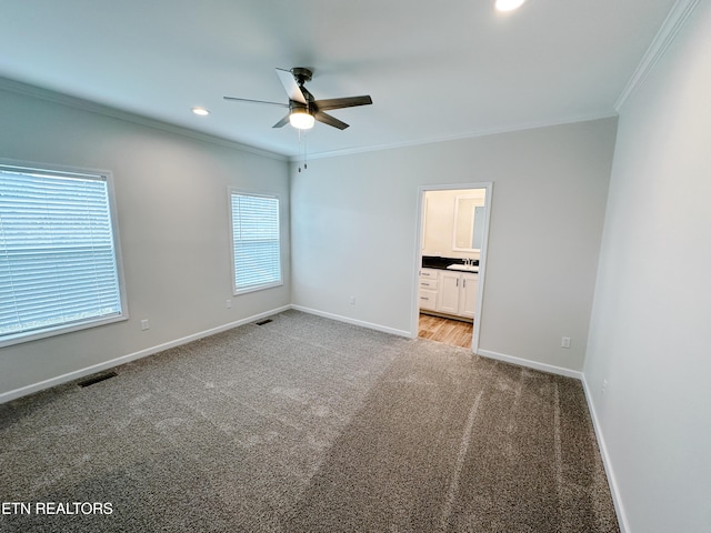 unfurnished bedroom with light carpet, sink, ornamental molding, and ensuite bathroom