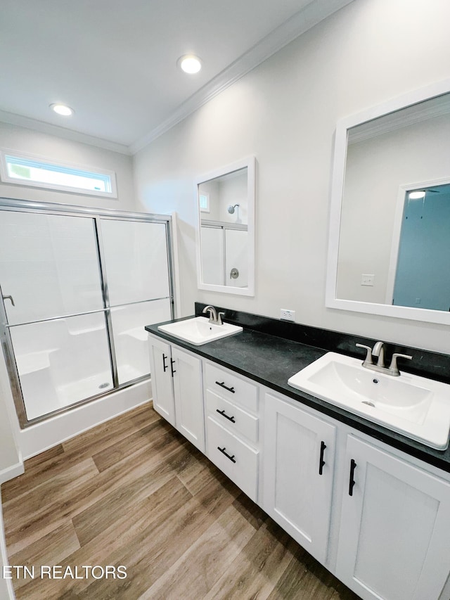 bathroom with an enclosed shower, hardwood / wood-style floors, crown molding, and vanity