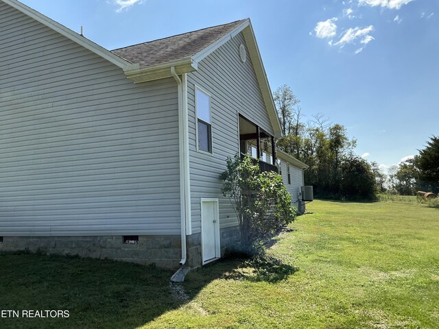 view of property exterior featuring central AC unit and a yard