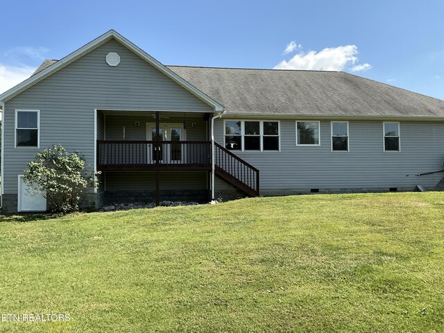 rear view of property with a lawn and a deck