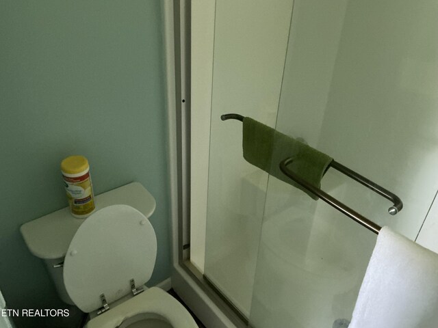 bathroom featuring toilet and an enclosed shower