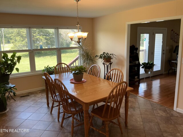 dining room featuring a notable chandelier, hardwood / wood-style flooring, and plenty of natural light