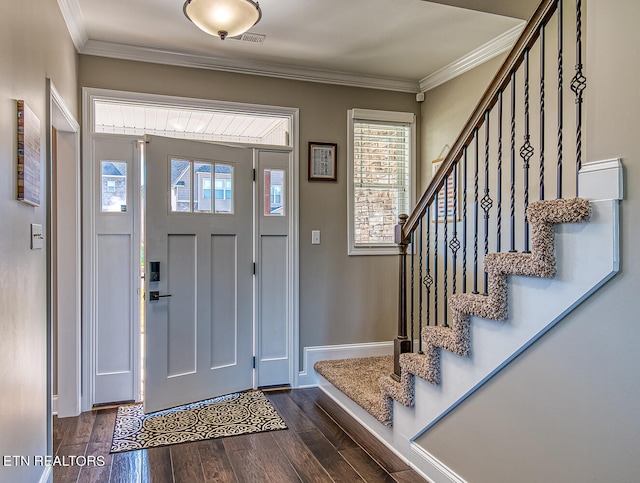 entryway with ornamental molding and dark hardwood / wood-style floors