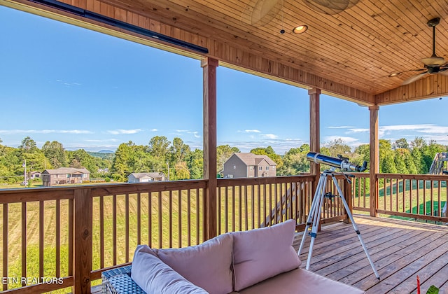 wooden deck featuring an outdoor hangout area, a lawn, and ceiling fan