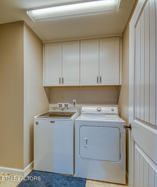 washroom featuring washing machine and clothes dryer, cabinets, and light tile patterned floors