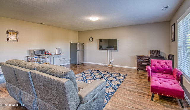 living room featuring hardwood / wood-style floors and a textured ceiling