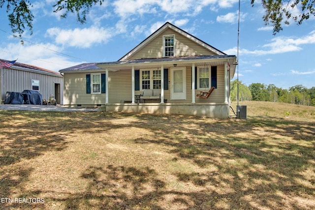 view of front facade with a front lawn, a porch, and central AC