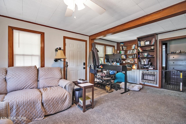 carpeted living room with ceiling fan, heating unit, and ornamental molding