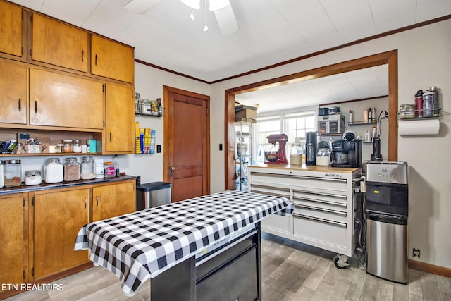 kitchen featuring light hardwood / wood-style floors, ornamental molding, and ceiling fan