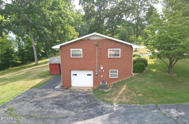 view of home's exterior with a yard, a garage, and central AC