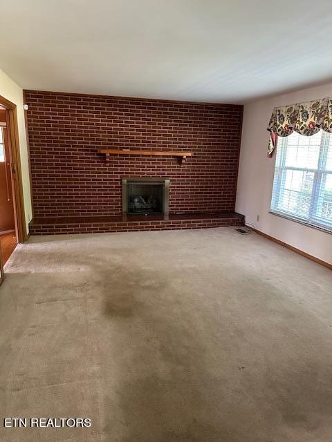 unfurnished living room featuring a brick fireplace