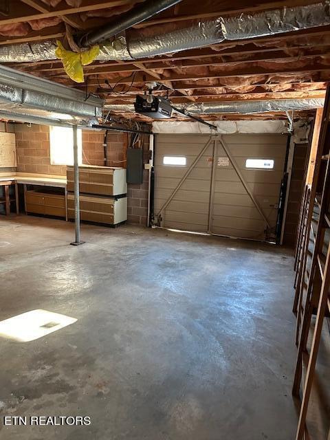 garage featuring electric panel and a garage door opener