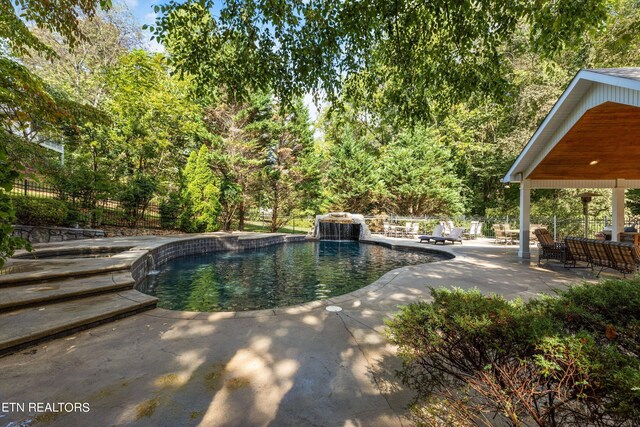 view of pool featuring pool water feature and a patio