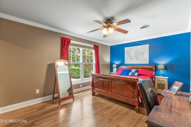 bedroom with ceiling fan, ornamental molding, a textured ceiling, and light hardwood / wood-style floors