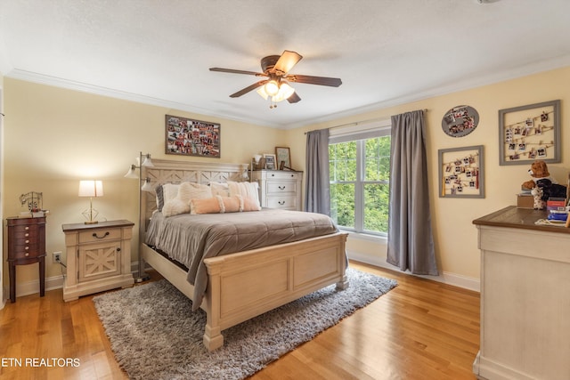 bedroom featuring ornamental molding, ceiling fan, and light hardwood / wood-style flooring