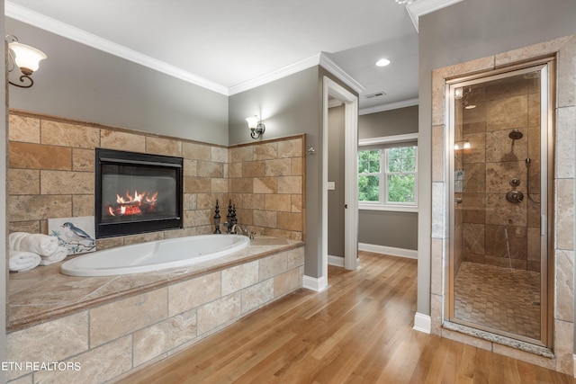 bathroom with ornamental molding, wood-type flooring, and independent shower and bath