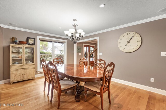 dining area with crown molding, light hardwood / wood-style flooring, and a chandelier