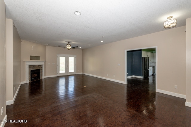 unfurnished living room with ceiling fan, a textured ceiling, dark hardwood / wood-style floors, and french doors