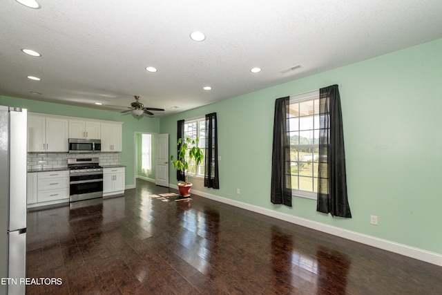 kitchen featuring ceiling fan, a textured ceiling, white cabinetry, appliances with stainless steel finishes, and dark hardwood / wood-style flooring