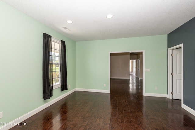 unfurnished room featuring a textured ceiling and dark wood-type flooring