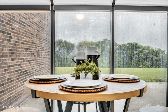 interior space with brick wall and a healthy amount of sunlight