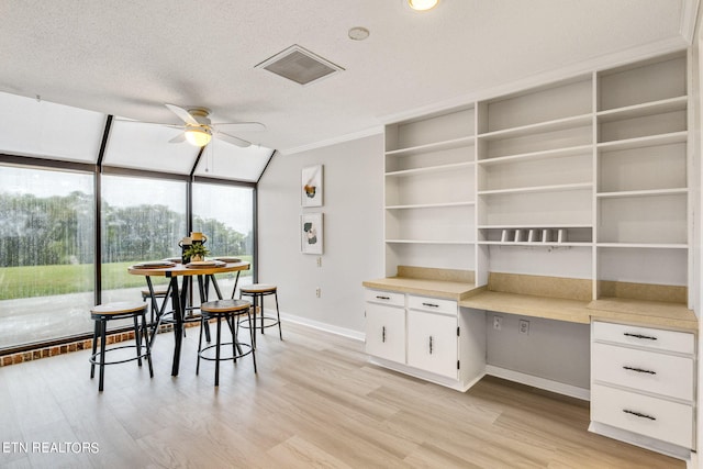 dining space with a textured ceiling, light hardwood / wood-style floors, ceiling fan, and built in desk