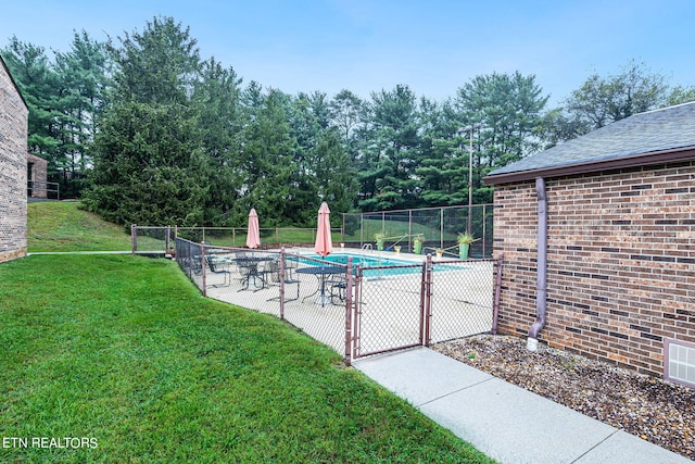 view of pool featuring a lawn and a patio