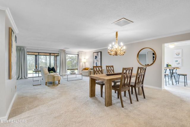 dining room featuring a textured ceiling, ornamental molding, light carpet, and a chandelier