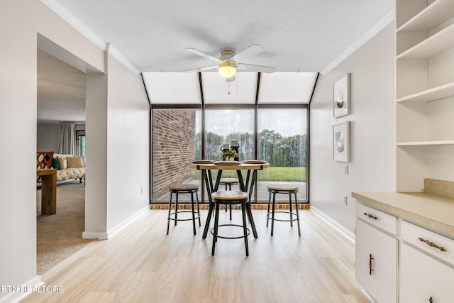 dining space featuring a textured ceiling, light hardwood / wood-style flooring, and ornamental molding