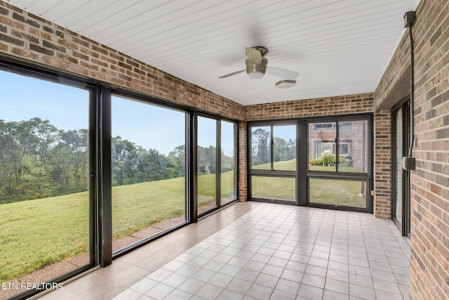 unfurnished sunroom featuring ceiling fan