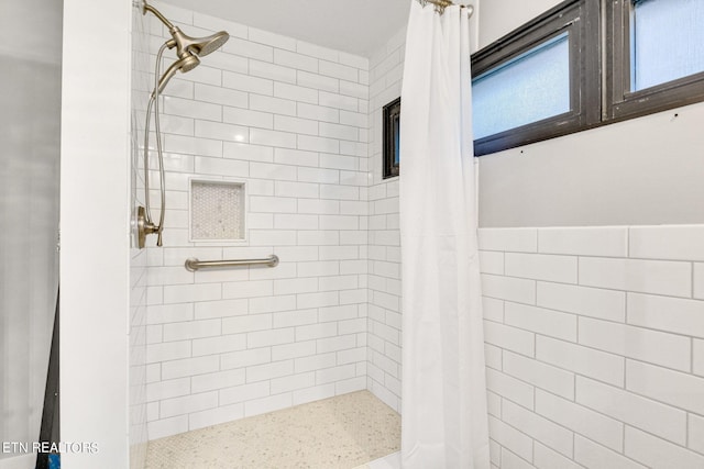 bathroom featuring walk in shower and tile walls