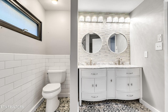 bathroom with tile walls, tile patterned flooring, vanity, and toilet