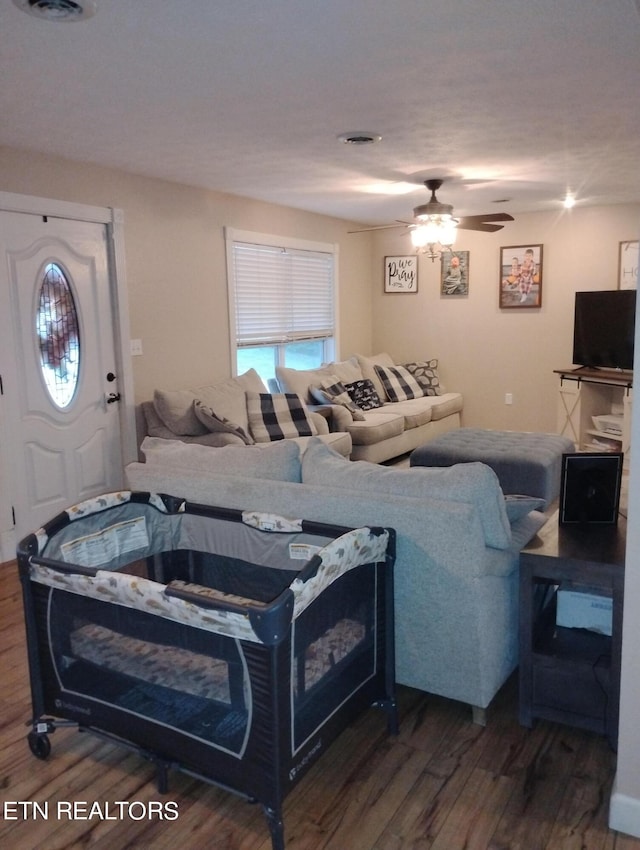 living room with ceiling fan and dark wood-type flooring