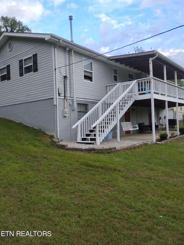 rear view of house featuring a deck and a yard