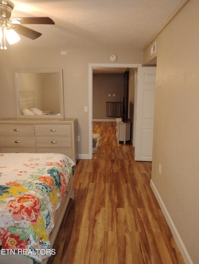 bedroom featuring a textured ceiling, ceiling fan, and hardwood / wood-style flooring