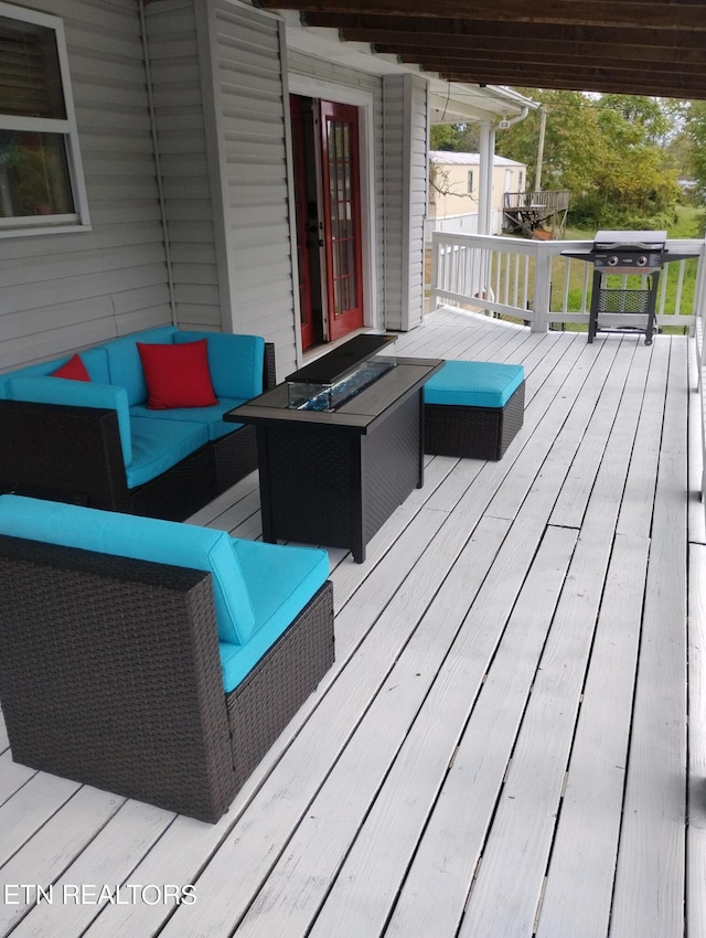 deck featuring grilling area and an outdoor living space with a fire pit