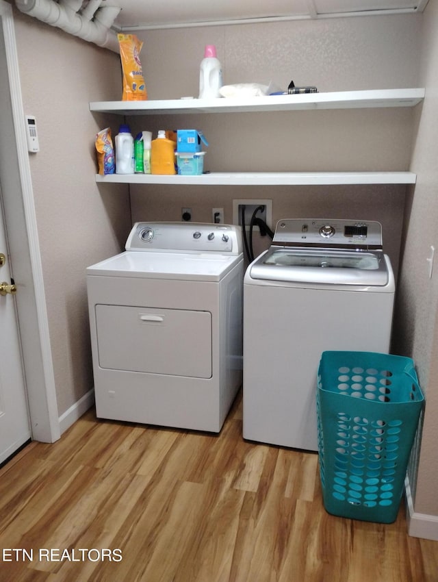 washroom featuring washer and clothes dryer and light hardwood / wood-style floors