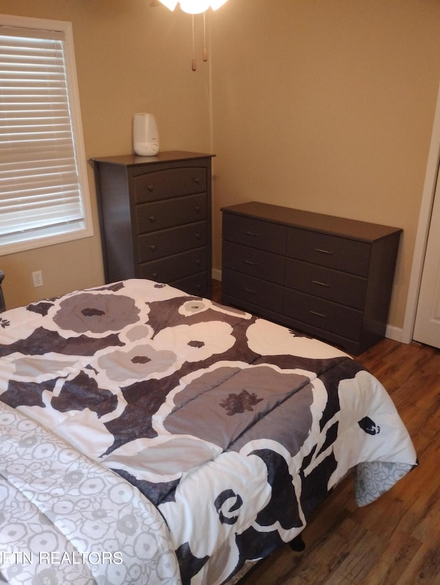 bedroom with dark hardwood / wood-style flooring