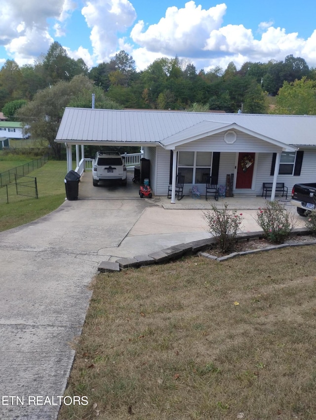 view of side of home featuring a carport, a yard, and a porch